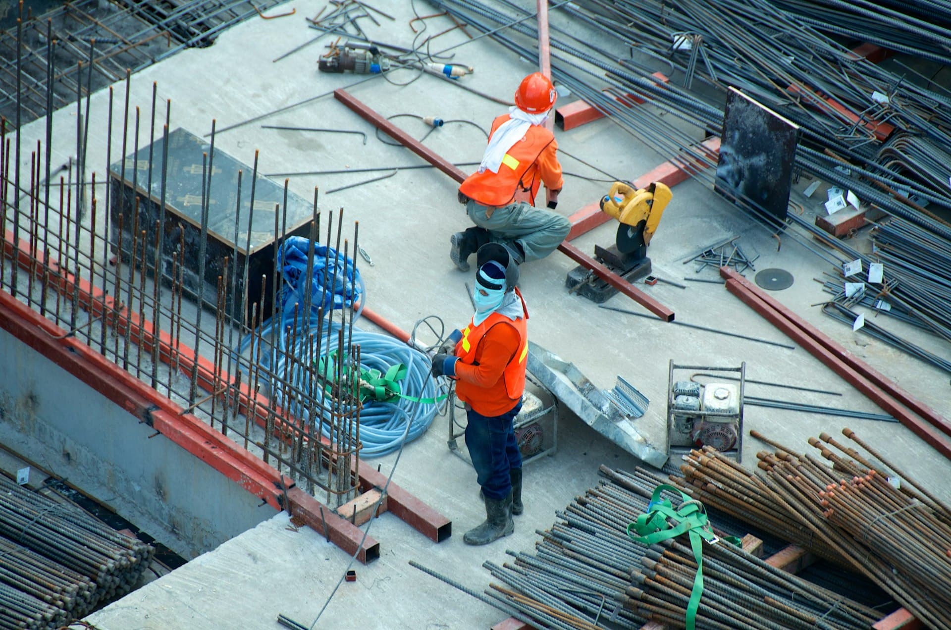Ouvriers d'ARBUATTI CONSTRUCTIONS sur un chantier de structure béton armé, ferraillage au sol